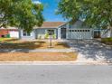 Single-story home with a tidy front yard and a driveway leading to the attached garage at 329 Drake Elm Dr, Kissimmee, FL 34743
