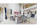 Bright living room with tall ceilings, staircase, modern fireplace and tiled floors at 4002 Scarlet Branch Rd, Orlando, FL 32824