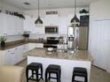 Bright kitchen boasts white cabinets, stainless steel appliances, and a central island at 411 Evening Sky Dr, Oviedo, FL 32765