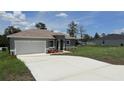 Beautiful single-story home showcasing a long driveway and manicured front lawn at 4111 Sw 166Th Place Rd, Ocala, FL 34473