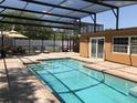 Screened-in pool area with brick pavers, lounge chairs, and dining set at 4251 Anthony Lane, Orlando, FL 32822