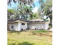 Rear view of home, showcasing manicured lawn, exterior paint, and mature landscaping at 513 Rachael Ct, Oviedo, FL 32765