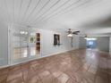 Expansive living room showcasing tile flooring, ceiling fans, and access to the kitchen and backyard at 52 Hydrangea Ln, Debary, FL 32713
