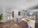 Spacious living room with neutral-toned sofas, shaggy rug, ceiling fans, and access to the backyard at 52 Hydrangea Ln, Debary, FL 32713