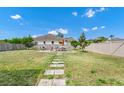 Large backyard features a stone path, patio with outdoor seating, and a privacy fence at 5431 White Heron Pl, Oviedo, FL 32765