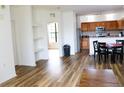 Bright living room with wood floors, shelving, and open access to a well-equipped kitchen and a sunlit den at 6117 Metrowest Blvd # 106, Orlando, FL 32835