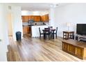 Open-concept living room with wood floors flowing into the kitchen, bright lighting, and minimalist decor at 6117 Metrowest Blvd # 106, Orlando, FL 32835