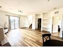 Spacious living room with hardwood floors, neutral walls, and access to a private outdoor balcony at 6117 Metrowest Blvd # 106, Orlando, FL 32835