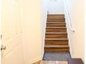 Staircase with beautiful wood steps ascending, featuring a sturdy white handrail and natural light at 6117 Metrowest Blvd # 106, Orlando, FL 32835