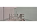 Silver 'HOME' decor displayed on a glass corner shelf at 1557 Sandbagger Dr, Davenport, FL 33896