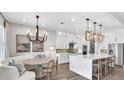 Open-concept kitchen with a large island, modern lighting, and stainless steel appliances at 161 Purcell Dr, Alafaya, FL 32825