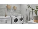 Well-equipped laundry room with white washer and dryer and stylish decor at 161 Purcell Dr, Alafaya, FL 32825