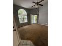 Spacious living room featuring a large arched window, sliding door to balcony, and ceiling fan at 2585 Grassy Point Dr # 313, Lake Mary, FL 32746