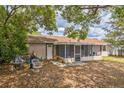 Backyard featuring covered porch and mature trees at 3 Spring Lane Way, Ocala, FL 34472