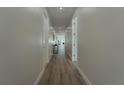 Bright hallway featuring wood floors and recessed lighting, leading to various rooms in the home at 59 W 10Th St, Apopka, FL 32703