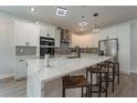 Modern kitchen featuring a large center island, stainless steel appliances and stylish pendant lighting at 59 W 10Th St, Apopka, FL 32703