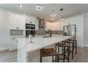Modern kitchen featuring white cabinetry, a large island with seating, and stainless steel appliances at 59 W 10Th St, Apopka, FL 32703