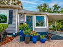 Inviting front entrance with blue door, brick path, and colorful potted plants adding charm at 1145 Utah Blvd, Orlando, FL 32803
