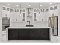 Modern kitchen featuring white cabinets, herringbone backsplash, a large black island, and stainless steel appliances at 16500 Magnolia Terrace Blvd, Montverde, FL 34756