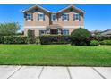 Charming two-story house featuring symmetrical design, dark shutters, and meticulously trimmed front hedges at 3008 Cardillino Way, Kissimmee, FL 34741