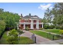 Elegant two-story brick home with large columns, well-manicured lawn, and mature trees at 690 E Church St, Bartow, FL 33830