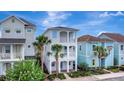 Inviting three-story home with double balconies, complemented by palm trees and colorful neighbors at 8044 Lost Shaker Ln, Kissimmee, FL 34747