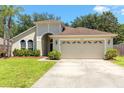 Well-maintained single-story home with manicured lawn and attached two-car garage at 830 Grand Hughey Ct, Apopka, FL 32712