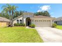 Charming single-story home featuring a well-manicured lawn and attached two-car garage at 830 Grand Hughey Ct, Apopka, FL 32712