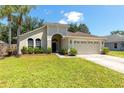 Charming single-story home featuring a well-manicured lawn and attached two-car garage at 830 Grand Hughey Ct, Apopka, FL 32712