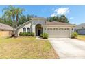 Well maintained single-story home with an attached two-car garage and mature landscaping at 830 Grand Hughey Ct, Apopka, FL 32712