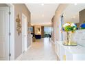 Elegant entryway with decorative mirror, white console table, and open floor plan at 9312 Sommerset Hills Dr, Davenport, FL 33896
