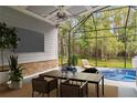 Spacious screened patio with ceiling fan, outdoor furniture, TV, and a relaxing hot tub at 1013 Maiden Ter, Celebration, FL 34747