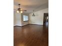 Spacious living room featuring hardwood floors, natural light, ceiling fan and hanging light fixture at 1105 Mill Run Cir, Apopka, FL 32703