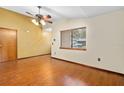 Living room with wood floors, a ceiling fan, and a window with natural lighting at 1105 Mill Run Cir, Apopka, FL 32703