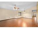 Open living room with hardwood floors, ceiling fan, and natural light from the window at 1105 Mill Run Cir, Apopka, FL 32703