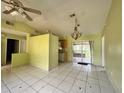 Dining area with tile flooring, vaulted ceiling, and access to sliding glass doors to the backyard at 132 Acapulco Dr, Kissimmee, FL 34743