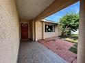 Cozy front porch with tile flooring, front door, and a view of a tree at 132 Acapulco Dr, Kissimmee, FL 34743
