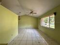 Bright living room with high ceilings, ceiling fan, and large windows offering natural light at 132 Acapulco Dr, Kissimmee, FL 34743