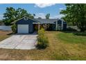 Charming single-story home with a well-manicured lawn, attached garage, and blue exterior paint at 1671 Judith Dr, Kissimmee, FL 34758