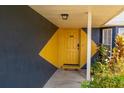 Vibrant yellow front door with geometric design on a blue exterior and covered porch at 1671 Judith Dr, Kissimmee, FL 34758