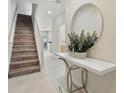 Bright entryway with stairs, a modern table, and a stylish round mirror at 17349 Serenidad Blvd, Clermont, FL 34714