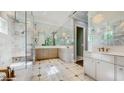 This bathroom features marble walls and floors, a spacious walk-in shower, and dual vanities with modern fixtures at 1761 Legion Dr, Winter Park, FL 32789