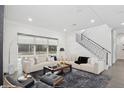 Bright living room featuring a large window, staircase, and contemporary furnishings for stylish comfort at 1761 Legion Dr, Winter Park, FL 32789