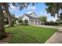 Beautifully landscaped side view of a modern home featuring a three-car garage and well-manicured lawn at 1761 Legion Dr, Winter Park, FL 32789