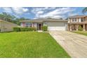 Charming single-story home with a well-manicured lawn and a two-car garage at 177 Bristol Forest Trl, Sanford, FL 32771