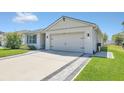 Spacious driveway featuring decorative pavers lining the edges, leading to a two-car garage and the home's entrance at 1866 Cassidy Knoll Dr, Kissimmee, FL 34744