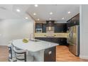 Modern kitchen features dark cabinets, stainless steel appliances, and a light countertop island at 2167 Pearl Cider St, Orlando, FL 32824