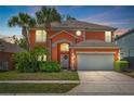 Charming two-story home featuring an attached two-car garage with mature landscaping at 2769 Lido Key Dr, Kissimmee, FL 34747