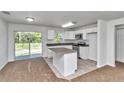 Modern kitchen with island, stainless appliances, granite countertops, and adjacent dining area at 3914 Sw 161St Loop, Ocala, FL 34473