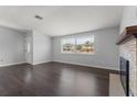 Inviting room boasts sleek hardwood floors, a cozy fireplace, and ample natural light from a large window at 4070 Mcneil Rd, Apopka, FL 32703